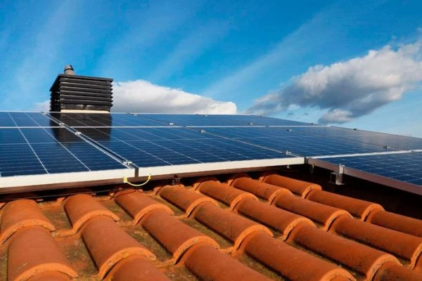 Unidad de aerotermia con placas solares en el tejado